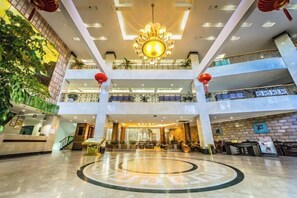 A spacious lobby with a central circular design, multiple floors, and a chandelier. - Meihai Hotel Wuyishan (Wuyishan)