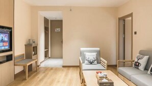 Un salon moderne avec un téléviseur à écran plat, un banc en bois, un canapé et une table basse.