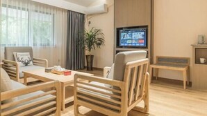 Un salon moderne avec un canapé en bois, une table en bois et un téléviseur fixé au mur.