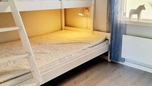 A bunk bed with a ladder, a desk with a lamp, and a window with a view of the outside. - 4 Person Holiday Home in Uddevalla (Uddevalla)