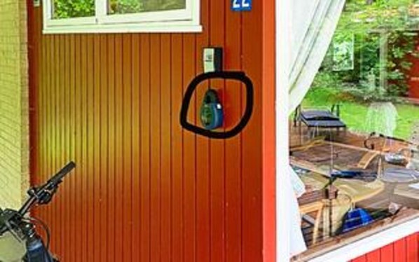 Ett rum med ett fönster, en dörr och utsikt över en trädgård.