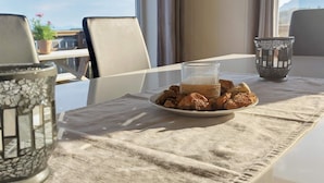 Un tavolo da pranzo con un piatto di biscotti e un bicchiere di latte, una candela decorativa e vista sull'esterno.