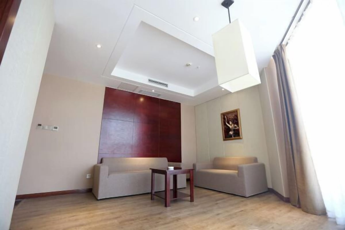 A modern living room with two sofas, a small table, and a ceiling light.
