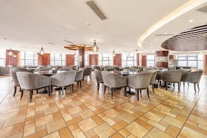 Un espace intérieur spacieux, aménagé avec plusieurs tables et chaises, idéal pour les repas ou les réunions.