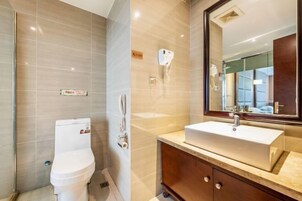 A modern bathroom with a toilet, sink, and mirror.