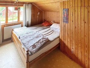 A single bed in a room with wooden walls and a sloped ceiling. - 7 Person Holiday Home in Algaras (Älgarås)