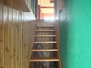 A wooden staircase with a green wall on one side.