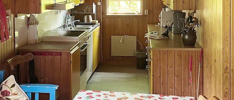 A compact kitchen with wooden cabinets, a sink, and a window.