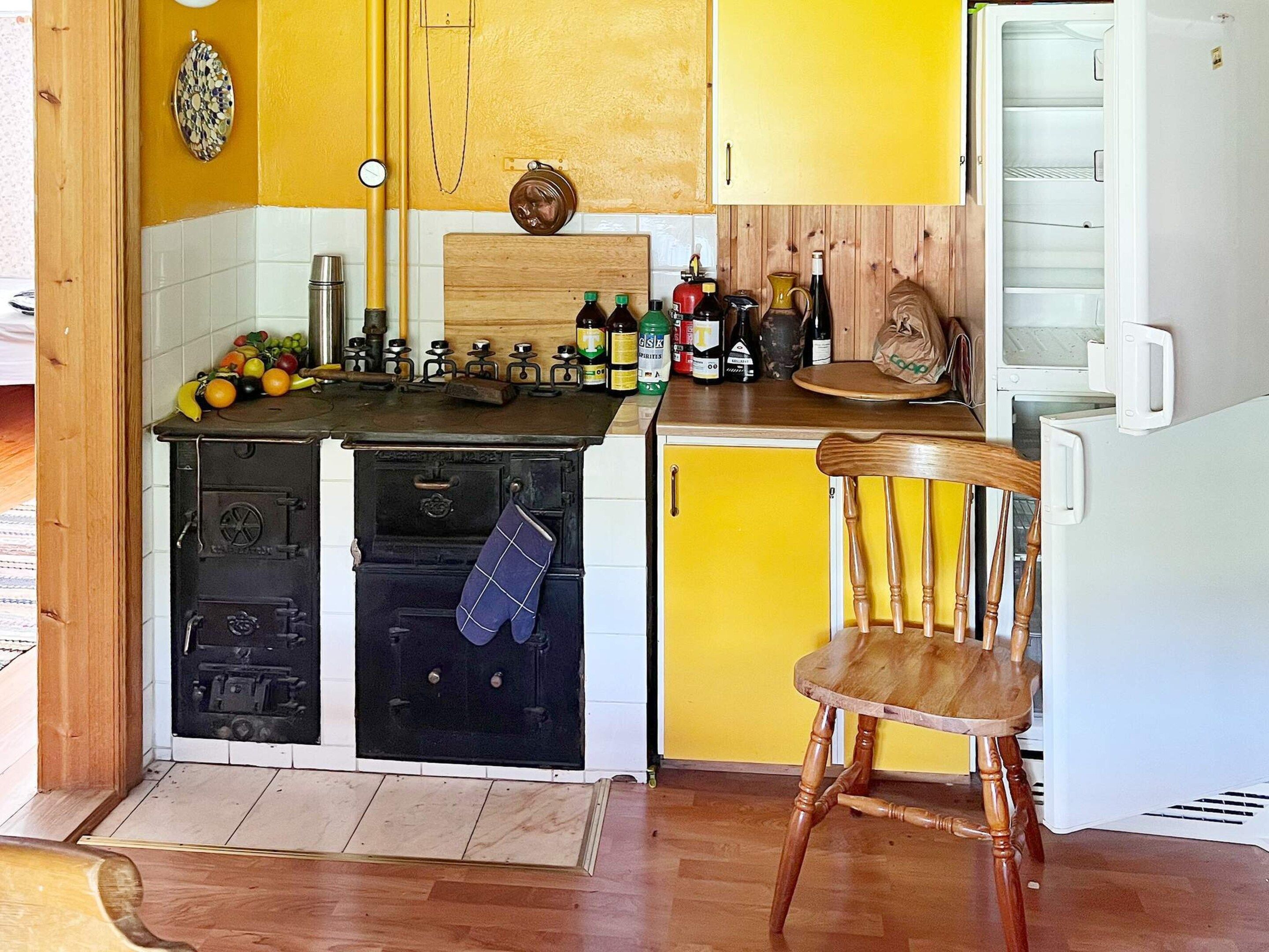 A compact kitchen with a stove, oven, and a small refrigerator.