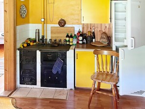 A compact kitchen with a stove, oven, and a small refrigerator. - 7 Person Holiday Home in Algaras (Älgarås)