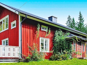 A red wooden house with white trim, a small porch, and a chimney. - 7 Person Holiday Home in Algaras (Älgarås)