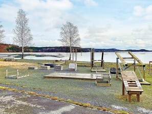 Um parque à beira do lago com mesas para piquenique, um deck de madeira e uma plataforma de observação.