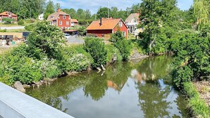A riverside view with red-roofed houses and lush greenery. - 7 Person Holiday Home in Edsbruk-by Traum (Edsbruk)