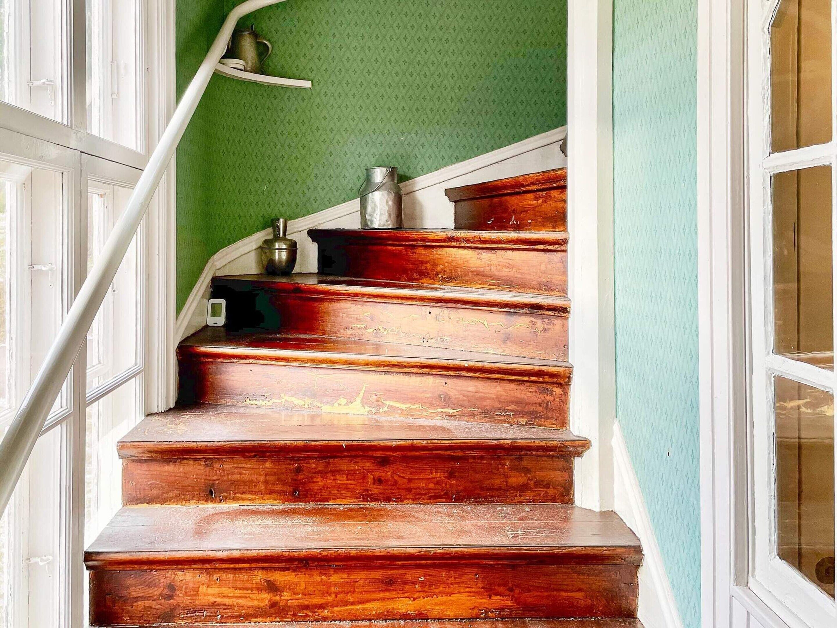 A wooden staircase with a metal container on the top step.