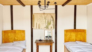 A room with two beds, a wooden table, and a wall-mounted light fixture. - 7 Person Holiday Home in Edsbruk-by Traum (Edsbruk)