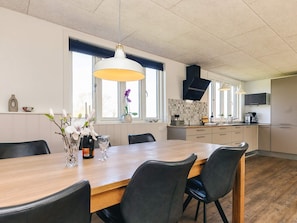 A modern kitchen with a dining area, large windows, and a hanging light fixture. - 6 Person Holiday Home in Vinderup (Vinderup)