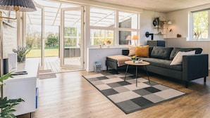 A modern living room with a sofa, coffee table, and a large window. - 6 Person Holiday Home in Vinderup (Vinderup)