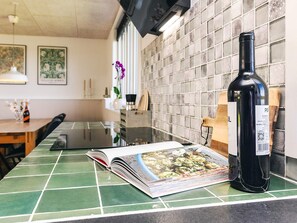 A kitchen counter with a wine bottle, a magazine, and a wooden cutting board. - 6 Person Holiday Home in Vinderup (Vinderup)