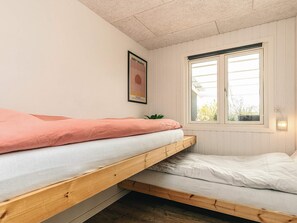 A room with a bunk bed, a poster on the wall, and a window with a view of greenery. - 6 Person Holiday Home in Vinderup (Vinderup)