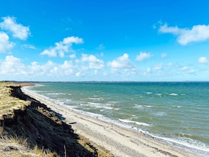 A coastal beach with a clear sky and gentle waves. - 6 Person Holiday Home in Vinderup (Vinderup)