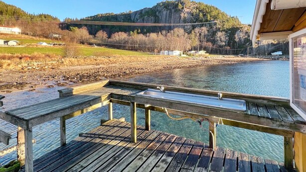 A wooden deck with a view of a river and a mountain. - 4 Person Holiday Home in Sundlandet-by Traum (Hitra)