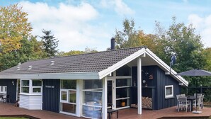 A modern house with a deck, large windows, and a chimney. - 6 Person Holiday Home in Farso (Farso)