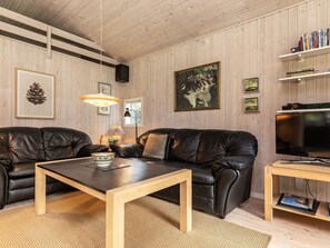 A living room with two leather sofas, a wooden coffee table, a TV, and a bookshelf. - 6 Person Holiday Home in Farso (Farso)