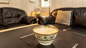 A room with two black leather sofas, a table with a decorative bowl, and a lamp. - 6 Person Holiday Home in Farso (Farso)