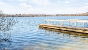 A wooden pier extending into a calm lake with a clear sky above. - 7 Person Holiday Home in Ansager (Ansager)