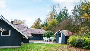A two-story house with a front yard and a small shed.