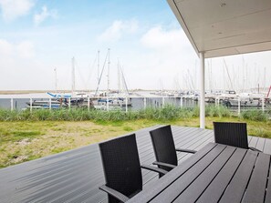 Ett utomhusområde med sittplatser och utsikt över en småbåtshamn.