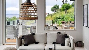A modern living room with a sofa, a coffee table, and a hanging light fixture. - Stylish Seaside Villa on Ven-by Traum (Sankt Ibb)