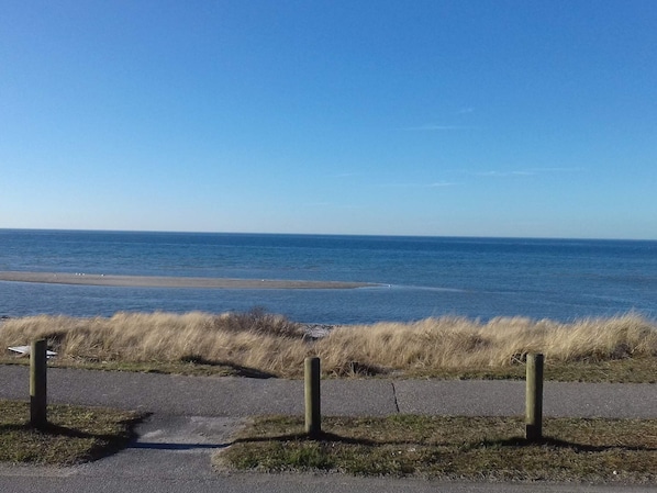 A coastal road with grassy areas and a clear view of the sea.