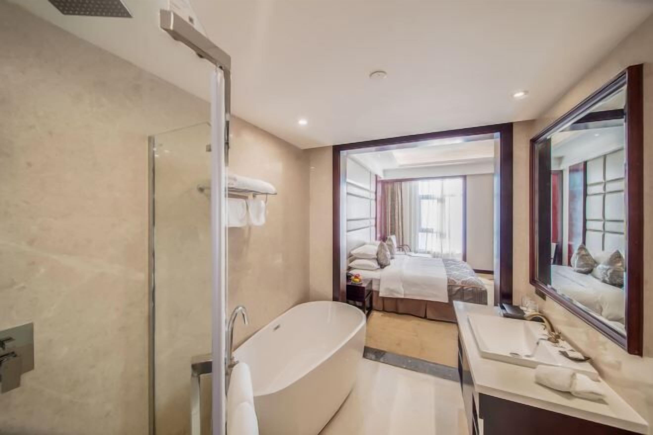 A modern bathroom with a freestanding bathtub, a glass-enclosed shower, and a large mirror.