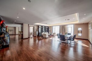 Un amplio salón con mesa de comedor, sofás y un ventanal grande.