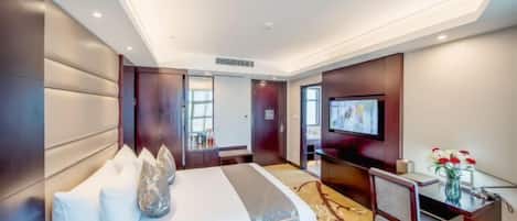 Una habitación de hotel moderna con una cama grande, un escritorio, un televisor y vistas a la ciudad.