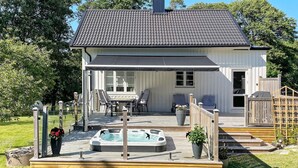 Une maison dotée d’un patio couvert, d’un jacuzzi et d’un espace salon extérieur.