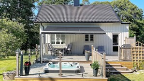 Une maison dotée d’un patio couvert, d’un jacuzzi et d’un espace salon extérieur.