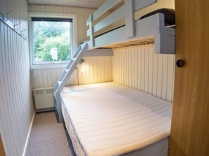 A bunk bed room with a window, a radiator, and a door. - 6 Person Holiday Home in Thyholm (Thyholm)