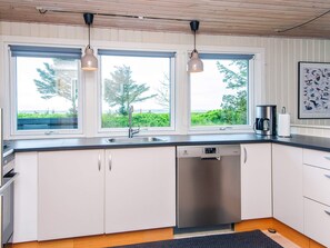 A modern kitchen with a dishwasher, double sink, and pendant lights. - 6 Person Holiday Home in Thyholm (Thyholm)