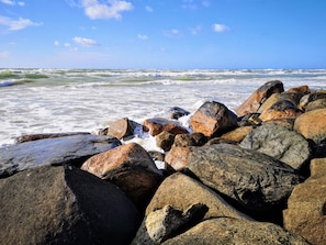 A rocky shoreline with waves crashing against the rocks.