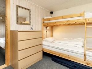 A bunk bed with a wooden frame, a dresser with multiple drawers, a mirror, and a bedside lamp. - 8 Person Holiday Home in Lokken (Lokken)