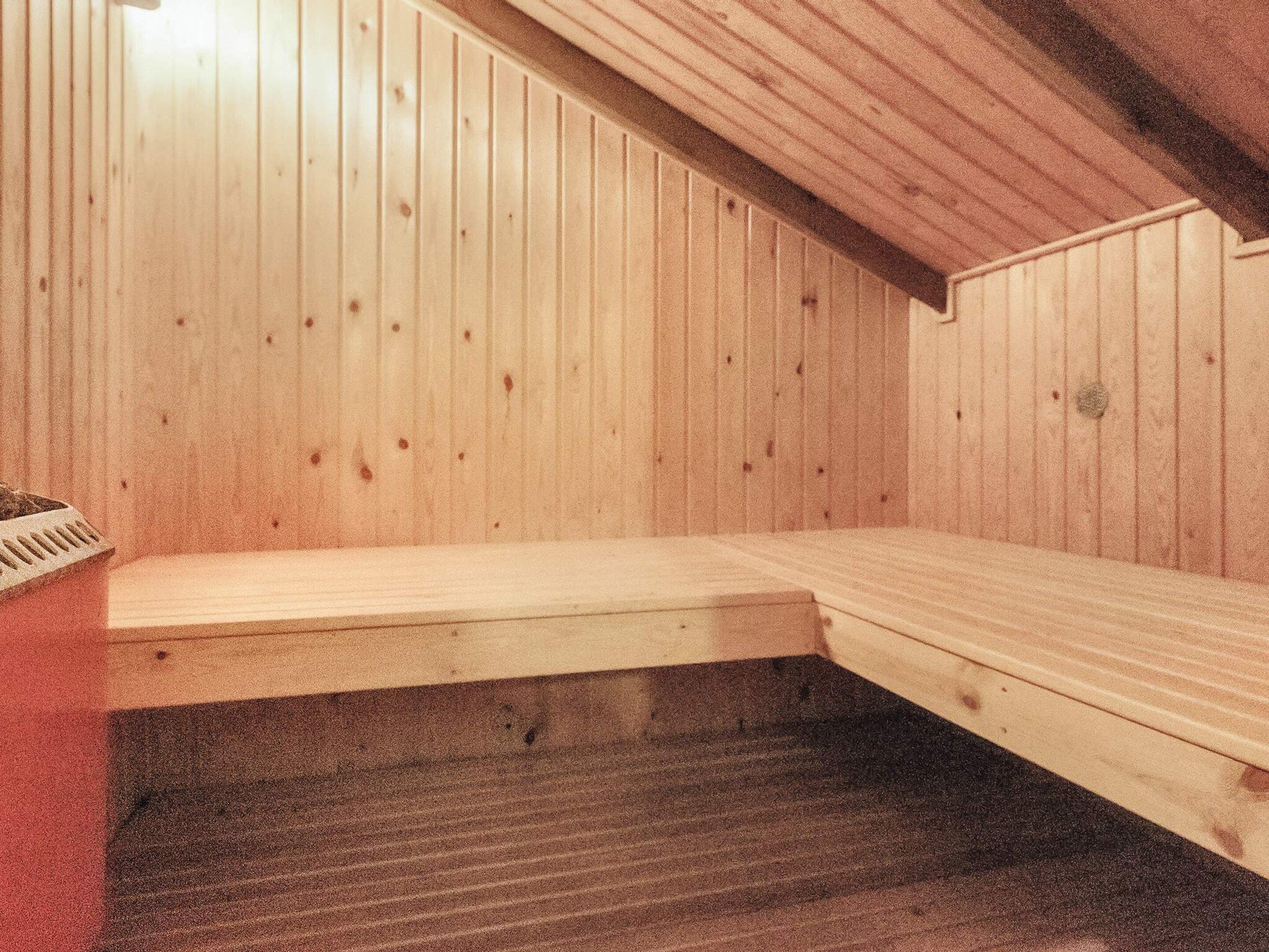 A sauna room with wooden walls and benches.