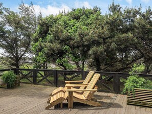 Una terraza de madera con una silla y un banco, ambos de madera.