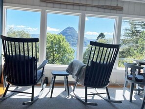A room with two rocking chairs facing a large window with a mountain view. - 4 Person Holiday Home in Svelgen (Bremanger)