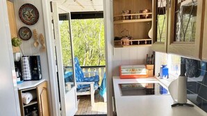 Een compacte keuken met uitzicht op de omgeving, een klein zithoekje en een eettafel.