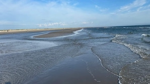 Una platja amb amplàries sorrenques i onades suaus.