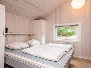 A bedroom with two beds, a window with a view of greenery, and wooden walls. - 8 Person Holiday Home in Fano (Fano)
