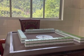 A Mahjong game setup on a table with a window view. - Emei Mountain Lakeview Inn (Emeishan City)