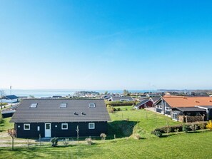 A residential area with houses, a clear sky, and a body of water in the distance. - 10 Person Holiday Home in Ronde (Ronde)